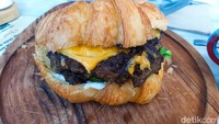 Menu brunch yang favorit di Moonsieur Spoon adalah Wagyu Croissant Burger (Rp 78 ribu). Berupa croissant butter yang dibelah dua untuk bun burger. Di dalamnya berisikan patty dari beef wagyu yang lembut dan juicy dan dipadukan dengan selada, keju cheddar, serta caramelized onion. Foto: detikFood/Yenny Mustika Sari