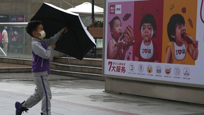 Pasutri di China Sekarang Boleh Punya Tiga Anak A child holds a dinosaur balloon during Childrens Day at a mall in Beijing on Tuesday, June 1, 2021. Chinas ruling Communist Party said it will ease birth limits to allow all couples to have three children instead of two in hopes of slowing the rapid aging of its population, which is adding to strains on the economy and society. (AP Photo/Ng Han Guan)