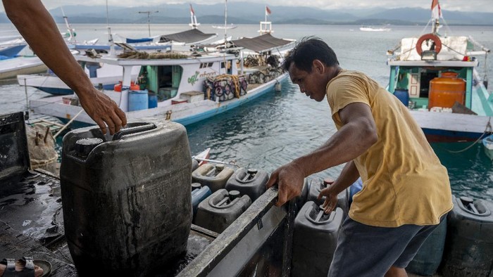 Pekerja menurunkan BBM jenis solar ke kapal nelayan di Pelabuhan Pendaratan Ikan (PPI) Donggala, Sulawesi Tengah, Selasa (1/6/2021). Pemerintah melalui  Kementerian ESDM akan mengonversi penggunaan bahan bakar minyak (BBM) ke bahan bakar gas (BBG) kepada para nelayan yang memiliki kapal penangkap ikan setara dengan 7.812 metric ton (MT). ANTARAFOTO/Basri Marzuki/rwa.