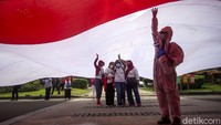 Sejumlah peserta aksi berfoto bersama saat bendera Merah Putih berukuran raksasa tersebut dibentangkan.
