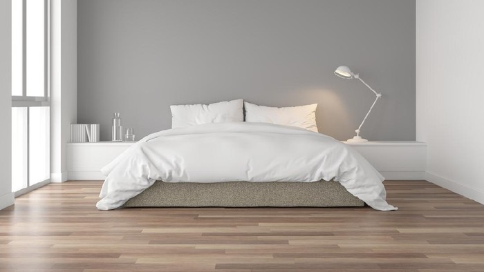 Minimal bedroom 3d render,There are wood floor and  gray wall.Furnished with brown fabric bed and white blanket .There are arch shape window nature light shining into the room.