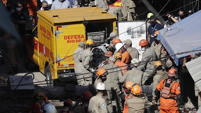 Bangunan Runtuh di Brasil Renggut Dua Nyawa Firefighters place into a Civil Defense vehicle, a body recovered from a four-story building that collapsed overnight in the Rio das Pedras slum of Rio de Janeiro, Brazil, early Thursday, June 3, 2021. The irregular construction in the working-class neighborhood, collapsed around 3:20 a.m. and also damaged nearby residences. (AP Photo/Bruna Prado)