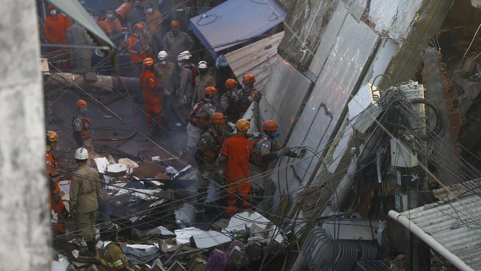 Bangunan Runtuh di Brasil Renggut Dua Nyawa Firefighters place into a Civil Defense vehicle, a body recovered from a four-story building that collapsed overnight in the Rio das Pedras slum of Rio de Janeiro, Brazil, early Thursday, June 3, 2021. The irregular construction in the working-class neighborhood, collapsed around 3:20 a.m. and also damaged nearby residences. (AP Photo/Bruna Prado)