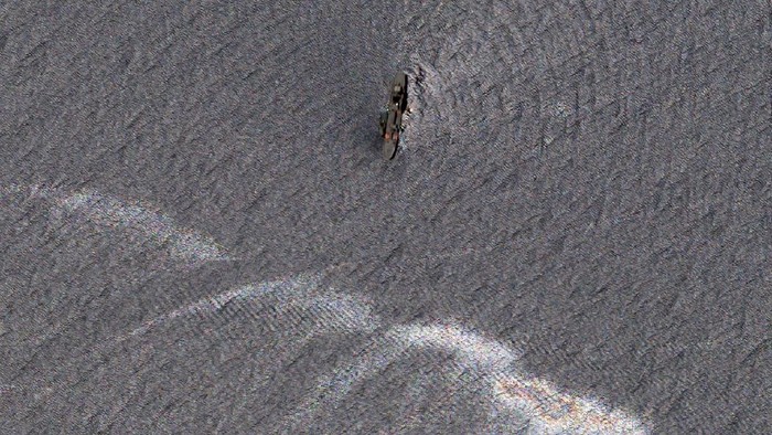Minyak dari Kapal Iran yang Terbakar Cemari Teluk Oman Oil-slicked waters spread out from the partially sunk Iranian navy vessel Kharg in the Gulf of Oman off the coast of Jask, Iran, in this Thursday, June 3, 2021, satellite photo from Planet Labs Inc. Satellite photographs taken Thursday show the burned hulk that remains of Iran's biggest warship after it caught fire and sank in the Gulf of Oman. (Planet Labs Inc. via AP)