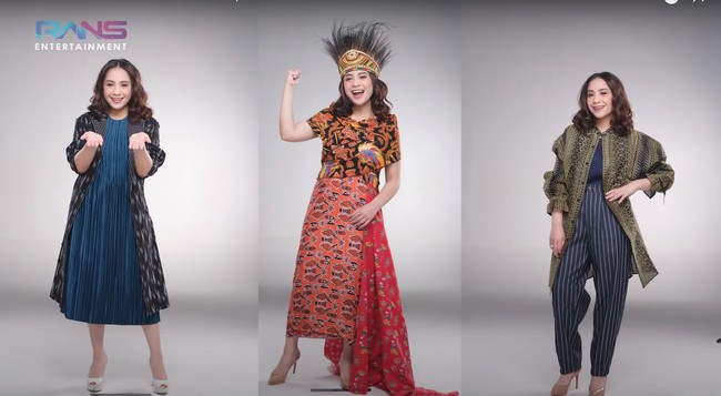 Tak hanya baju adat Papua, Nagita juga tampak mengenakan dua look lain. Pada look pertama, Nagita tampil dengan outer tenun Papua berwarna hitam, sedangkan pada look lainnya dirinya terlihat mengenakan celana high waist bermotif garis-garis dan outer tenun Papua berwarna hijau. Foto: YouTube/Rans Entertainment