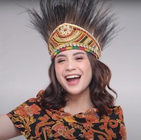 Nagita Slavina tampak cantik mengenakan baju adat Papua yang telah dimodifikasi. Lengkap dengan ikat kepala rumbai khas Papua, penampilan Nagita semakin mempesona. Foto: YouTube/Rans Entertainment