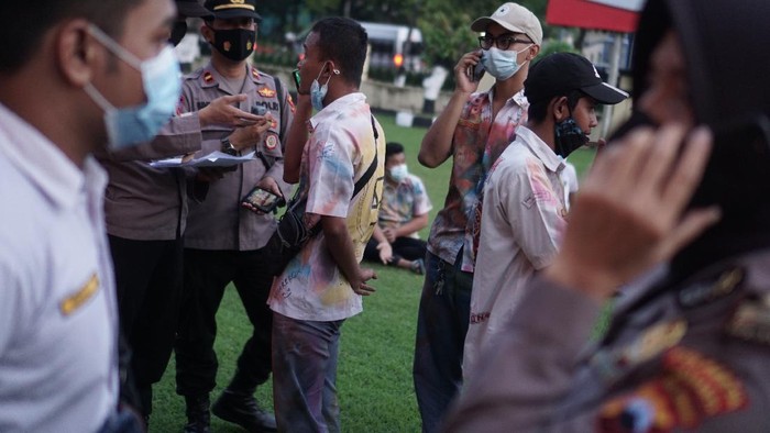 Anggota polisi menelepon orang tua pelajar yang terjaring razia konvoi kelulusan di Polresta, Solo, Jawa Tengah, Kamis (3/6/2021). Sebanyak 27 pelajar tingkat SMK terjaring razia polisi akibat melakukan konvoi kelulusan yang dinilai mengganggu kenyamanan masyarakat dan melanggar protokol kesehatan. ANTARA FOTO/Mohammad Ayudha/wsj.
