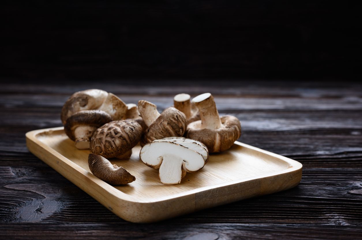 Shiitake mushrooms (Lentinus edodes) on the wooden background.