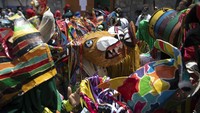 Orang-orang menari dengan kostum setan untuk merayakan hari raya Katolik Corpus Christi di Naiguata, Venezuela, Kamis (3/6/2021) waktu setempat.  