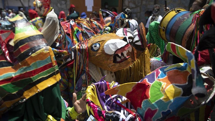 Unik! Ada Tarian Setan di Venezuela People dance in devil costumes to celebrate the Catholic holiday of Corpus Christi in Naiguata, Venezuela, Thursday, June 3, 2021. Carrying masks of animals and sea monsters, residents of all ages went out to dance in the ritual known as Dancing Devils that symbolizes the triumph of good over evil. (AP Photo/Ariana Cubillos)