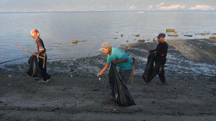AKSI GOTONG ROYONG BERSIHKAN PANTAI Warga memungut sampah saat aksi gotong royong membersihkan Pantai Dupa Indah di Palu, Sulawesi Tengah, Sabtu (5/6/2021). Aksi gotong royong membersihkan pantai oleh masyarakat tersebut sebagai bentuk kepedulian terhadap kelestarian lingkungan dan dalam rangka memperingati Hari Lingkungan Hidup Sedunia. ANTARA FOTO/Mohamad Hamzah/rwa.