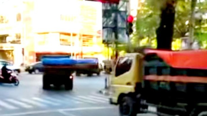 Iring-iringan truk menerobos lampu lalu lintas di Makassar.