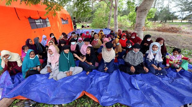 Pengungsi etnis Rohingya berada di Pulau Idaman, pesisir Pantai Kuala Simpang Ulim, Aceh Timur, Aceh, Sabtu (5/6/2021). Sebanyak 81 orang pengungsi etnis Rohingya dengan tujuan Malaysia yang terdampar di Aceh pada 4 Juni 2021 tersebut masih menunggu penanganan dari pihak terkait. ANTARA FOTO/Irwansyah Putra/rwa.