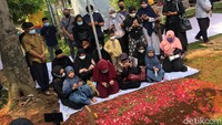Ria Ricis berusaha tegar melihat pusara sang ayah yang masih penuh dengan bunga. Foto: Asep/detikhot