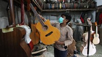 Perajin menyelesaikan pengerjaan gitar di Pucang Sawit, Solo, Jawa Tengah, Kamis (3/6). 