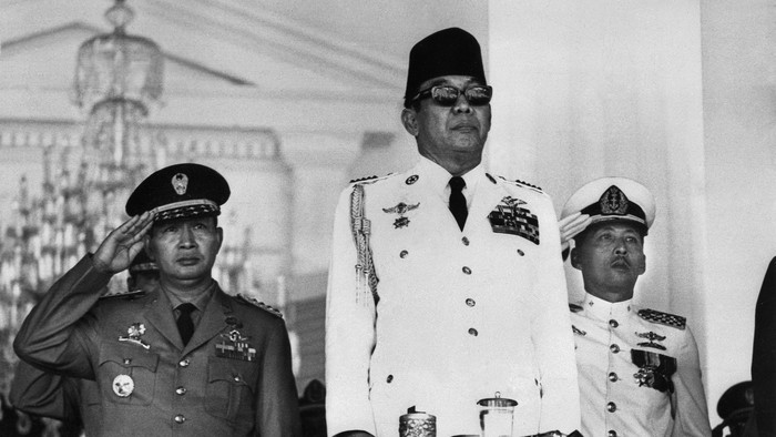 Indonesian President Ahmed Sukarno (C) attends a mass rally held at the Freedom Square in front of the Merdeka Palace, in Jakarta, 17 August 1966, to mark the Indonesias 21st anniversary of Independance from the Dutch. The Indonesian Army strongman Mohamed Suharto (L) stands in attention in the background. (Photo by AFP)