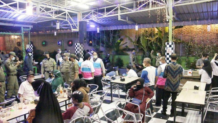 Sejumlah petugas tim Pemkot Medan membubarkan pengunjung salah satu cafe terletak di Jalan HM Joni, Medan