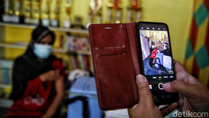 Vaksinator memberikan vaksin kepada warga di kawasan RPTRA Sindang Raya, Koja , Jakarta Utara, Senin (7/6). Vaksin tersebut diberikan kepada warga dengan rentang umur 18 - 58 tahun.