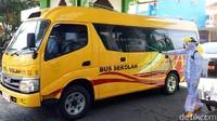 Saat masuk asrama haji, bus disemprot disinfektan oleh petugas mengenakan APD lengkap.