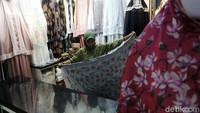 Pedagang merapikan dagangan di kiosnya di Pasar Tanah Abang, Jakarta.