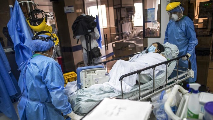 A healthcare worker tends to a COVID-19 patient in a tent set up on the soccer field of the Samaritana Hospital, in Bogota, Colombia, Thursday, June 3, 2021. Colombia has become a pandemic hotspot experiencing a third wave of COVID-19 infections and a surge in deaths. (AP Photo/Ivan Valencia)