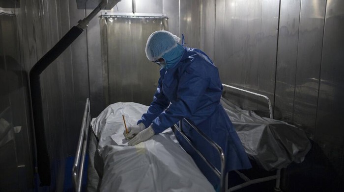 A healthcare worker tends to a COVID-19 patient in a tent set up on the soccer field of the Samaritana Hospital, in Bogota, Colombia, Thursday, June 3, 2021. Colombia has become a pandemic hotspot experiencing a third wave of COVID-19 infections and a surge in deaths. (AP Photo/Ivan Valencia)
