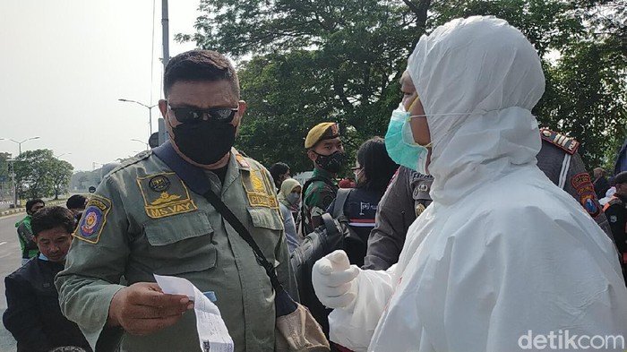 Penyekatan di Suramadu sisi Surabaya terus dilakukan. Pengendara roda dua diperiksa dan dites swab di lokasi.