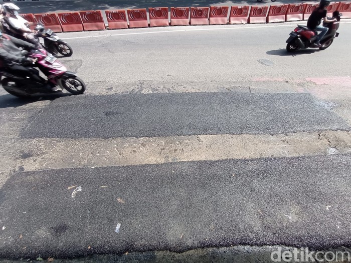 Permukaan jalan yang rusak dan berlubang depan Halte Transjakarta di Kuningan Timur kini sudah ditambal, 7 Juni 2021. (Wilda Hayatun Nufus/detikcom)