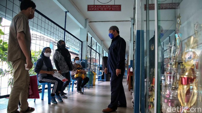 Posko PPDB SMPN 30 Siap Layani Warga Jakut Petugas melayani wali murid kawasan Posko PPDB SMPN 30, Koja, Jakarta Utara, Senin (7/6). Pendaftaran Peserta Didik Baru (PPDB) telah dibuka pada hari ini. Kegiatan PPDB ini dilakukan secara online dari rumah.