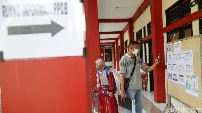 Wali murid mencari infomasi di posko Pendaftaran Penerimaan Peserta Didik Baru (PPDB) 2021 di SMA Negeri 17 Kota Bekasi, Jawa Barat, Senin (7/6/2021). Pendaftaran Penerimaan Peserta Didik Baru (PPDB) 2021 tahap 1 dibuka pada 7-11 Juni 2021. Sementara itu, untuk tahap 2 dimulai pada 25 Juni - 1 Juli 2021.