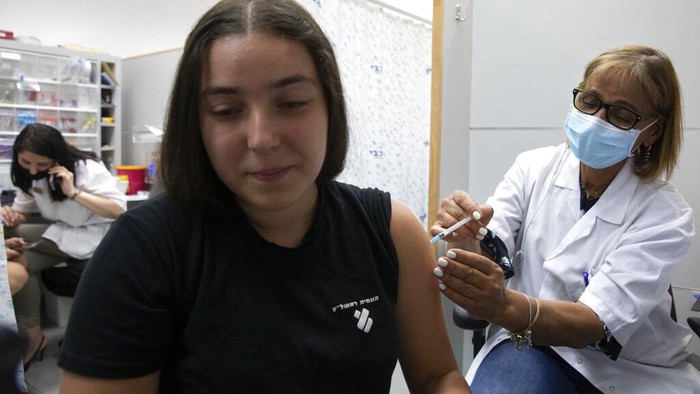 An Israeli youth receives a Pfizer-BioNTech COVID-19 vaccine in the central Israeli city of Rishon LeZion, Sunday, June 6, 2021. Israel started vaccinating children from 12 to 15 on Sunday. (AP Photo/Sebastian Scheiner)