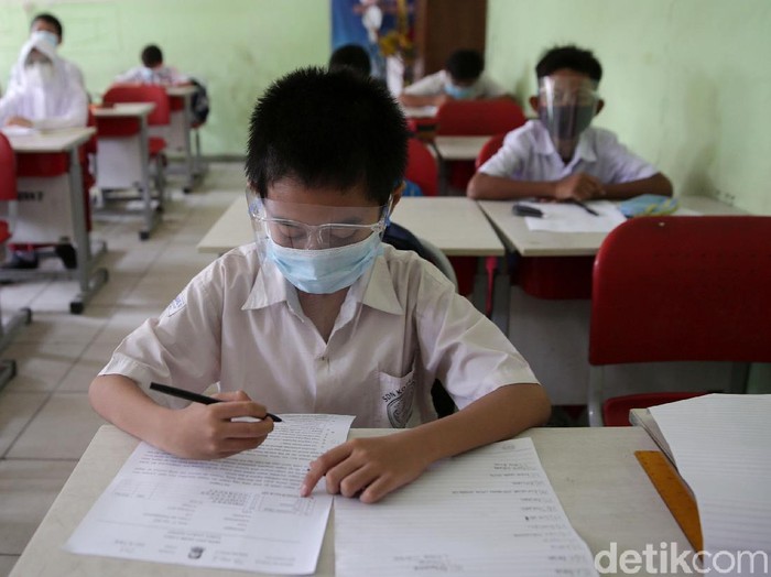 Siswa-Siswi kelas 5 menjalani ujian penilaian akhir sekolah di SD Negeri Kota Baru 2 dan 3, Bekasi Barat, Kota Bekasi, Jawa Barat, Senin (7/6/2021). Ujian ini dilaksanakan secara tatap muka dengan menerapakan protokol kesehatan yang ketat dan membagi beberapa sesi kelas untuk ujian. Satu kelas terdiri dari 15 anak. Ujian ini berlangsung hingga 12 Juni 2021. Hanya kelas 4 dan 5 yang melakukan ujian tatap muka kelas lainnya laksanakan ujian secara daring.