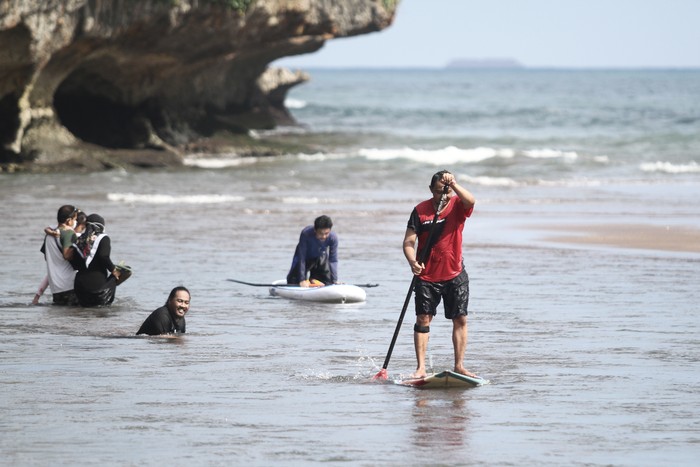 Wisatawan bermain air di kawasan Pantai Baron, Tanjungsari, Gunungkidul, DI Yogyakarta, Senin (7/6/2021). Destinasi wisata yang menawarkan pemandangan pantai dan kuliner makanan laut tersebut masih menjadi destinasi andalan di Gunungkidul. ANTARA FOTO/Hendra Nurdiyansyah/rwa.
