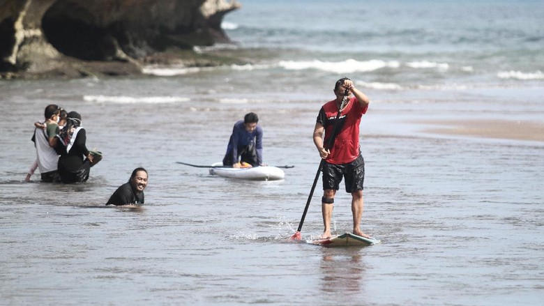 WISATA PANTAI BARON Wisatawan bermain air di kawasan Pantai Baron, Tanjungsari, Gunungkidul, DI Yogyakarta, Senin (7/6/2021). Destinasi wisata yang menawarkan pemandangan pantai dan kuliner makanan laut tersebut masih menjadi destinasi andalan di Gunungkidul. ANTARA FOTO/Hendra Nurdiyansyah/rwa.