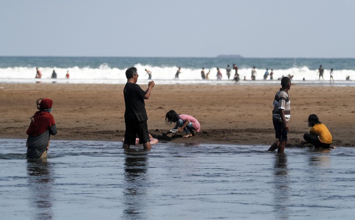 Wisatawan bermain air di kawasan Pantai Baron, Tanjungsari, Gunungkidul, DI Yogyakarta, Senin (7/6/2021). Destinasi wisata yang menawarkan pemandangan pantai dan kuliner makanan laut tersebut masih menjadi destinasi andalan di Gunungkidul. ANTARA FOTO/Hendra Nurdiyansyah/rwa.
