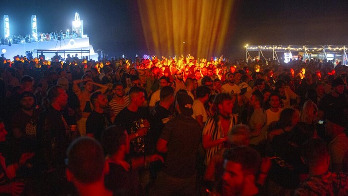 Thousands of Virus-free international fans participate at Unum Albania's open-air music festival in Shengjin on Friday, June 4, 2021. Organizers had sold all 10,000 planned tickets with more requests to follow from people around the world trying to forget the virus restrictions and follow non-stop music for five days at the Rana e Hedhun (Thrown Sand) beach, 75 kilometers (45 miles) northwest of the capital Tirana. (AP Photo/Visar Kryeziu)