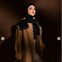 Tampilan modest nan modern ini dipadukan dengan celana dengan motif tartan ikonik Burberry serta blouse hitam. Foto: Instagram/@riomotret