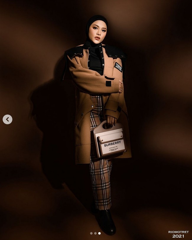 Wanita yang akrab disapa Loly ini juga terlihat menenteng tas kombinasi warna putih-camel, juga dari brand Burberry. Foto: Instagram/@riomotret