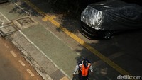 Petugas meminta pengendara mobil tidak parkir di atas trotoar.