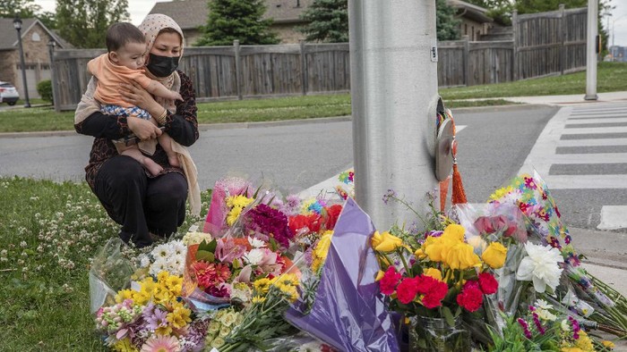 Duka untuk 4 Anggota Keluarga Muslim yang Tewas Diserang di Kanada People attend a memorial at the location where a family of five was hit by a driver, in London, Ontario, Monday, June 7, 2021. Four of the members of the family died and one is in critical condition. A 20-year-old male has been charged with four counts of first degree murder and count of attempted murder in connection with the crime. (Brett Gundlock/The Canadian Press via AP)