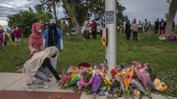 Duka untuk 4 Anggota Keluarga Muslim yang Tewas Diserang di Kanada People attend a memorial at the location where a family of five was hit by a driver, in London, Ontario, Monday, June 7, 2021. Four of the members of the family died and one is in critical condition. A 20-year-old male has been charged with four counts of first degree murder and count of attempted murder in connection with the crime. (Brett Gundlock/The Canadian Press via AP)