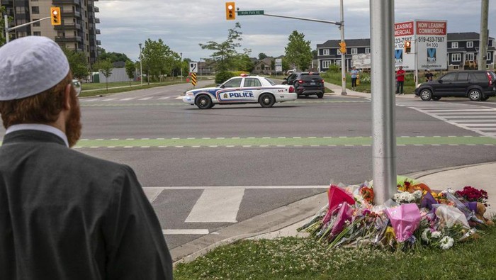 A police car passes the location where a family of five was hit by a driver, in London, Ontario, Monday, June 7, 2021. Four of the members of the family died and one is in critical condition. A 20-year-old male has been charged with four counts of first degree murder and count of attempted murder in connection with the crime. (Brett Gundlock/The Canadian Press via AP)