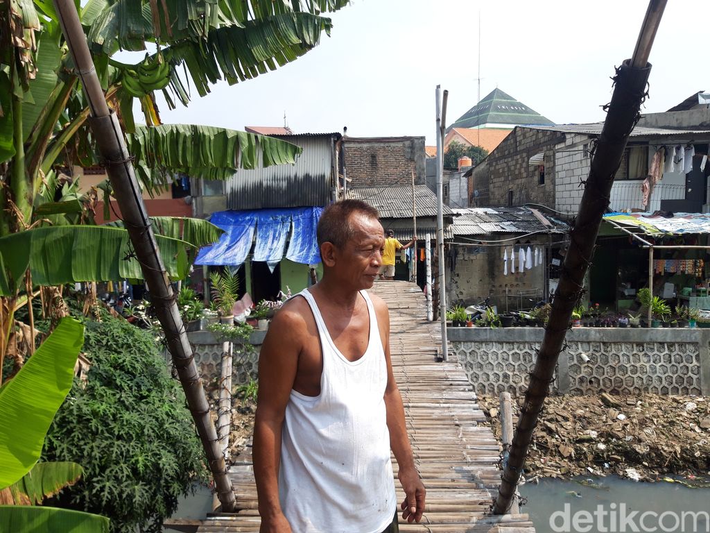 Nondol, warga Kampung Rawa di Kebon Jeruk, Jakarta Barat, di dekat jembatan bambu reyot. (Rakha AD/detikcom)