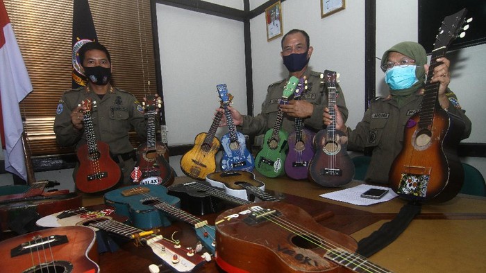 SATPOL PP RAZIA PENGAMEN JALANAN Petugas Satuan Polisi Pamong Praja (Satpol PP) Kota Pontianak memperlihatkan belasan alat musik petik hasil razia pengamen saat rilis di Mako Satpol PP Kota Pontianak, Kalimantan Barat, Senin (7/6/2021). Belasan alat musik petik berupa ukulele dan gitar tersebut merupakan hasil penjaringan dari pengamen di perempatan jalan yang telah meresahkan pengguna jalan dan mengganggu ketertiban umum. ANTARA FOTO/Jessica Helena Wuysang/rwa.