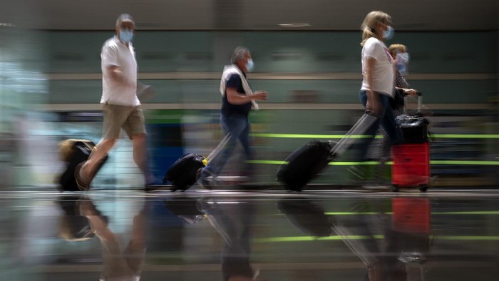 People arrive at Barcelona airport, Spain, Monday, June 7, 2021. Spain is trying to ramp up its tourism industry by welcoming from Monday vaccinated visitors from most countries, as well as all Europeans who prove that they are not infected with the coronavirus. (AP Photo/Emilio Morenatti)