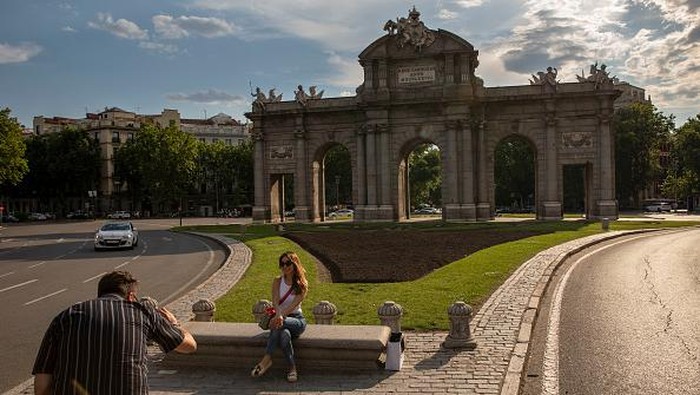 MADRID, SPAIN - JUNE 07: A tourist poses for a picture at Puerta de Alcala on June 07, 2021 in Madrid, Spain. Spain, the worlds second most visited tourism destination, has re-opened borders to vaccinated visitors worldwide as well as non-vaccinated Europeans with a negative antigen test. (Photo by Pablo Blazquez Dominguez/Getty Images)