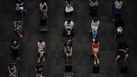 Orang-orang terlihat duduk sambil menunggu pemberian vaksin virus corona AstraZeneca di tempat vaksinasi massal di dalam pusat perbelanjaan Siam Paragon, Bangkok, Thailand, Senin (7/6/2021) waktu setempat.  