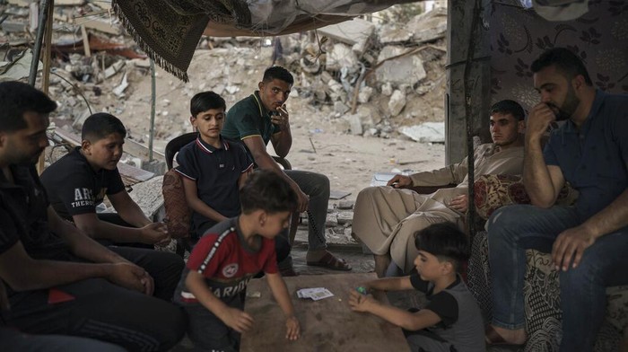 Warga Gaza Bertahan Hidup di Tengah Puing-puing Bangunan Palestinians look at the rubble of a building that collapsed after it was hit by airstrikes during an 11-day war between Gaza's Hamas rulers and Israel, in Gaza City, Tuesday, June 1, 2021. (AP Photo/Felipe Dana)