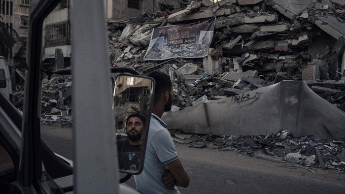 Palestinians look at the rubble of a building that collapsed after it was hit by airstrikes during an 11-day war between Gazas Hamas rulers and Israel, in Gaza City, Tuesday, June 1, 2021. (AP Photo/Felipe Dana)