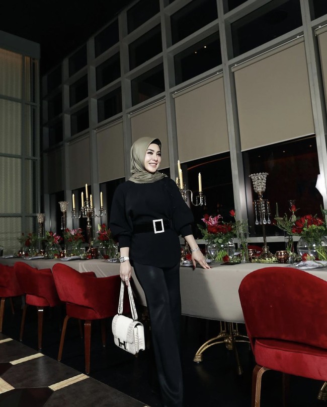 Syahrini tampil dengan gaya monokrom saat berpose di salah satu restoran milik suaminya Reino Barack. Dia bergaya dengan hijab dari brandnya sendiri Fatimah Syahrini. Foto: Dok. Instagram @princessyahrini.